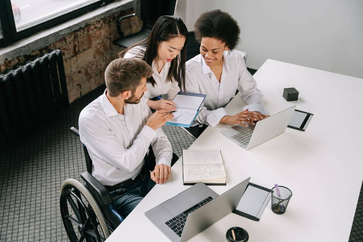 three individuals gathered around a desk